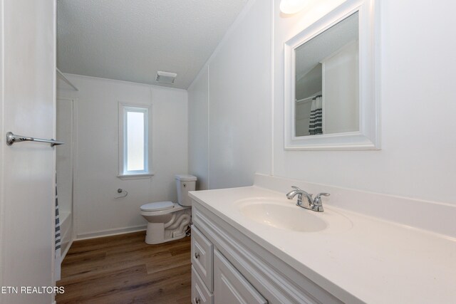 full bathroom featuring visible vents, toilet, vanity, wood finished floors, and a textured ceiling