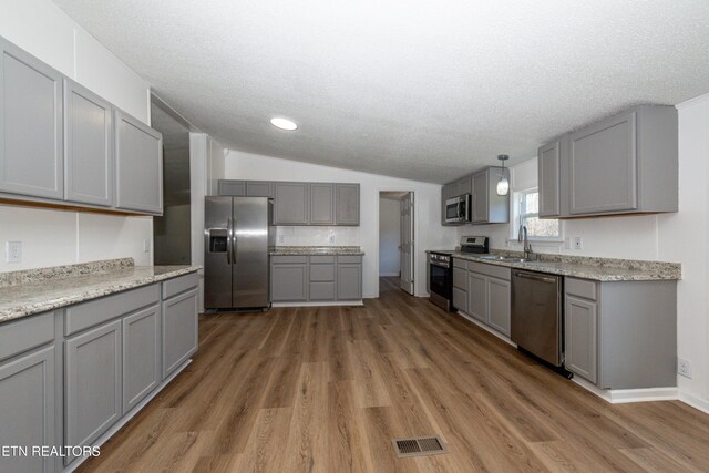 kitchen featuring a sink, gray cabinetry, visible vents, and stainless steel appliances