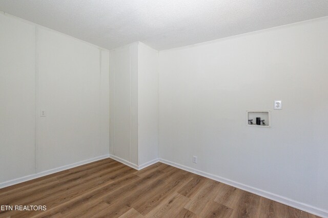 unfurnished room featuring wood finished floors, baseboards, and a textured ceiling