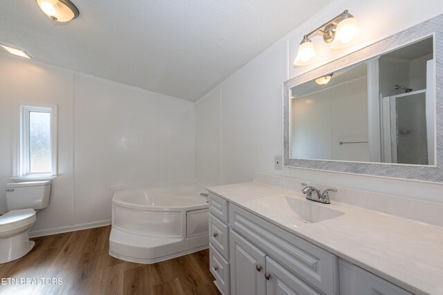 full bathroom featuring vanity, toilet, wood finished floors, and a bath