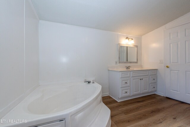 full bathroom with vanity, crown molding, a bath, and wood finished floors