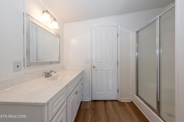 bathroom featuring vanity, a shower stall, and wood finished floors