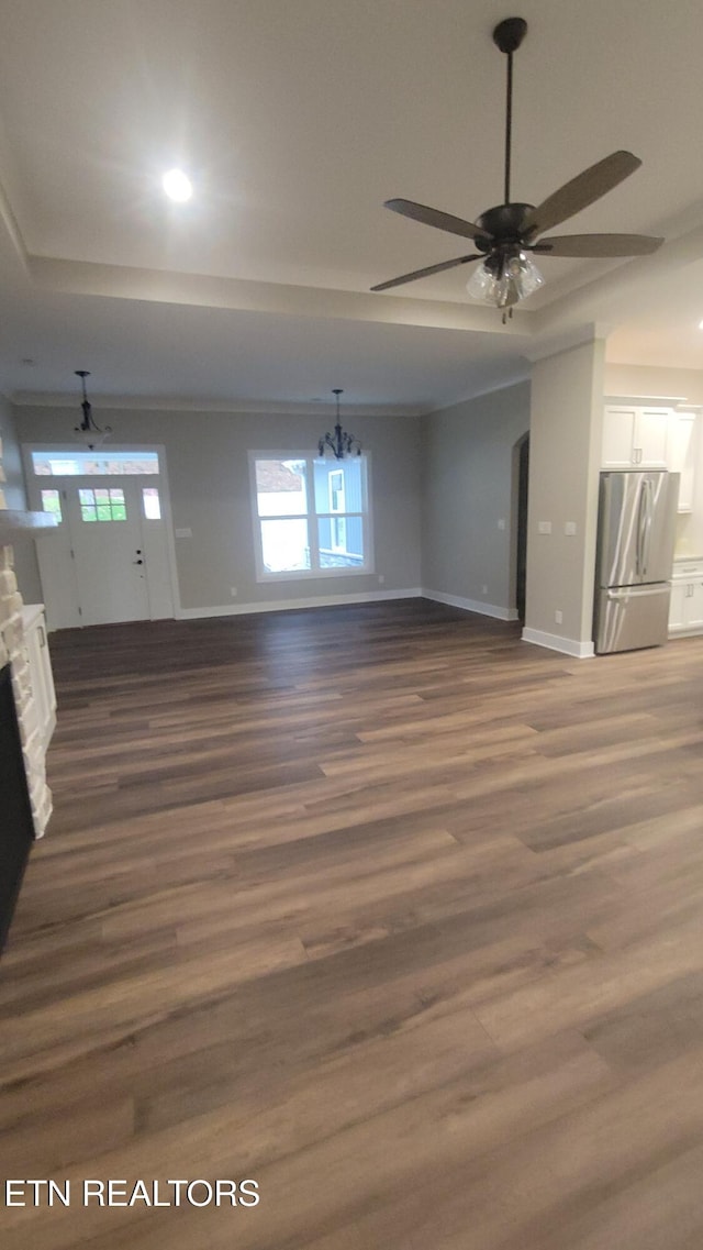 unfurnished living room featuring a fireplace, dark hardwood / wood-style flooring, and ceiling fan with notable chandelier