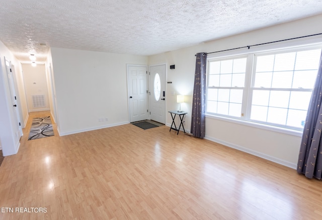 foyer entrance with a textured ceiling and hardwood / wood-style flooring