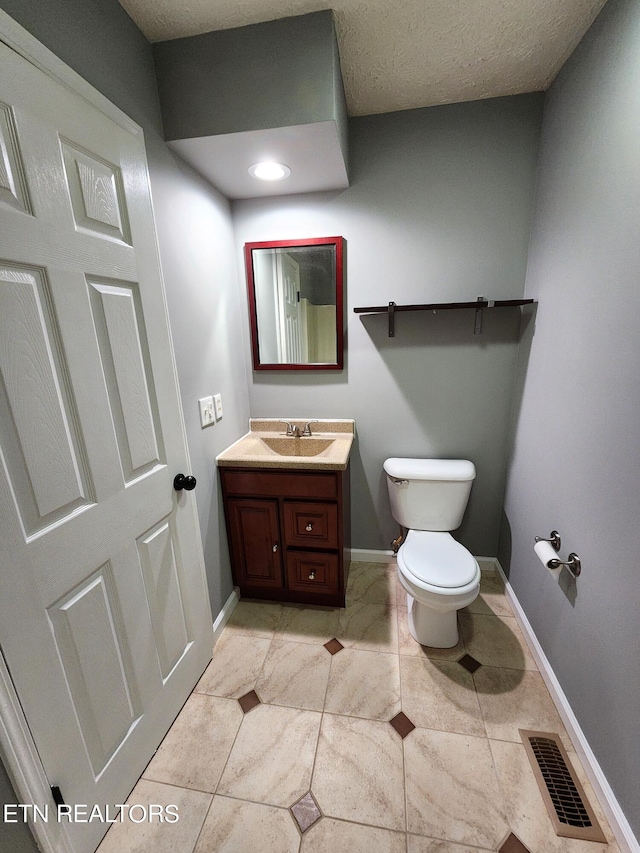 bathroom with tile patterned flooring, vanity, and toilet