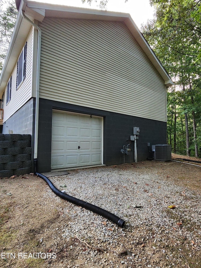 view of side of property with central AC unit and a garage