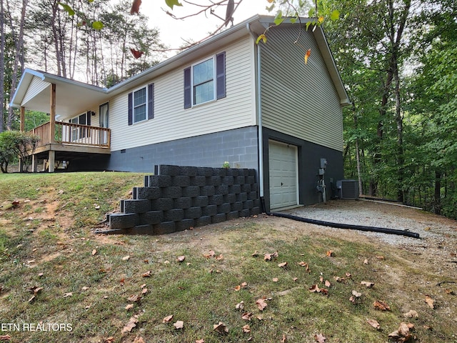 view of property exterior with central AC unit and a garage