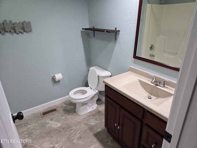 bathroom featuring a shower, vanity, and toilet