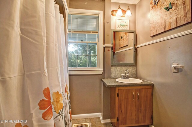 bathroom featuring vanity and decorative backsplash