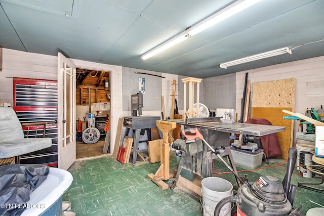 basement with wooden walls and a workshop area