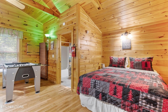 bedroom featuring light wood-type flooring, wooden ceiling, wood walls, and vaulted ceiling with beams