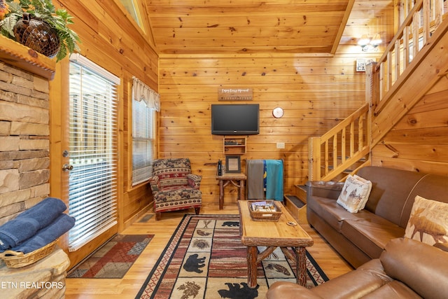 living room with wood walls, light hardwood / wood-style floors, wooden ceiling, and vaulted ceiling