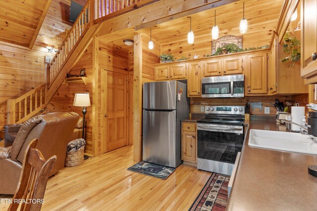 kitchen featuring light wood-type flooring, pendant lighting, stainless steel appliances, and wood ceiling