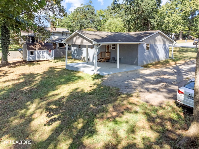 view of front of house with a front yard and a storage shed