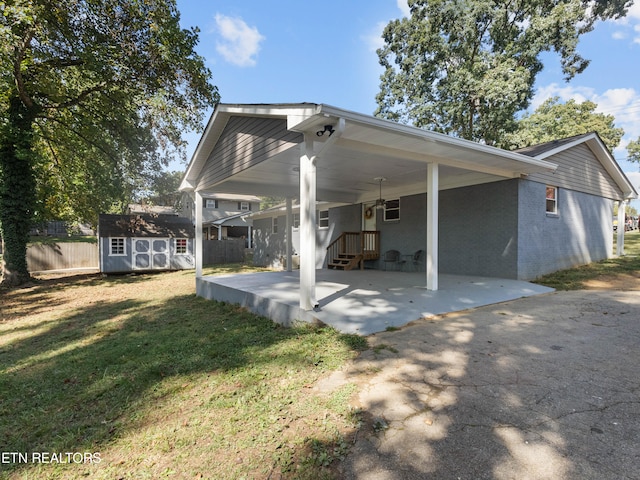 rear view of house with a lawn and a storage shed