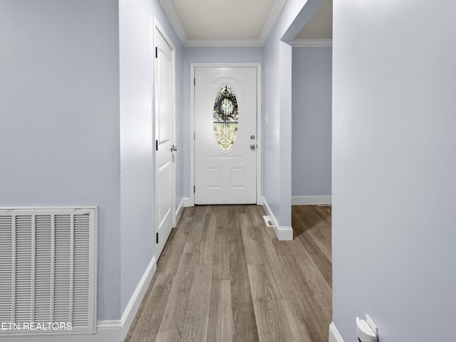 doorway to outside with light wood-type flooring and ornamental molding