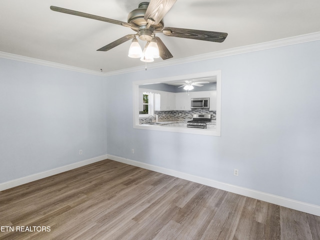 empty room featuring light wood-type flooring, ceiling fan, and crown molding