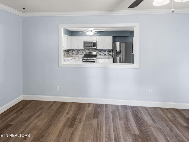 spare room featuring ornamental molding and dark wood-type flooring