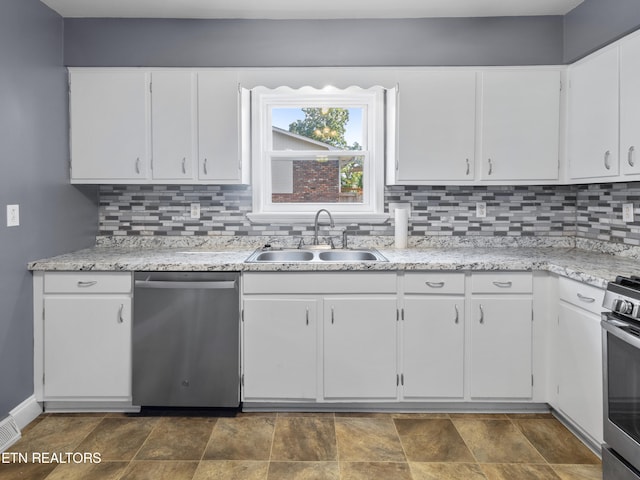 kitchen featuring white cabinets, appliances with stainless steel finishes, tasteful backsplash, and sink