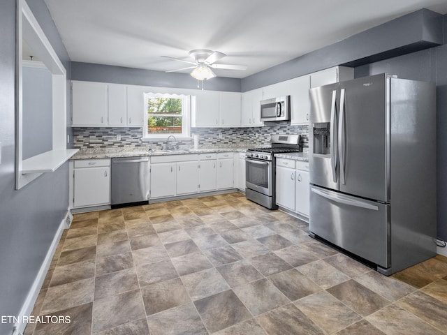 kitchen featuring decorative backsplash, sink, white cabinets, and stainless steel appliances