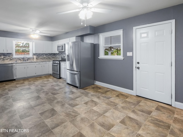 kitchen with white cabinets, sink, appliances with stainless steel finishes, and tasteful backsplash