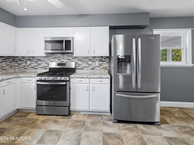 kitchen featuring backsplash, white cabinets, and stainless steel appliances