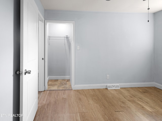 unfurnished bedroom with a closet and light hardwood / wood-style flooring