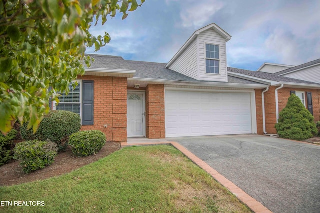 view of front of house featuring a garage and a front lawn