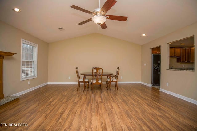 dining area featuring ceiling fan, wood-type flooring, and vaulted ceiling