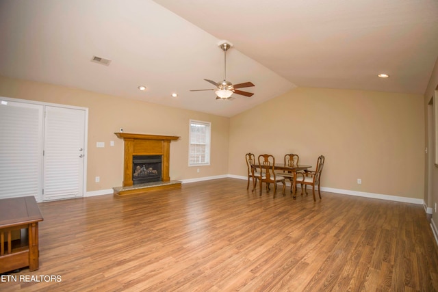 living room featuring hardwood / wood-style floors, ceiling fan, and vaulted ceiling