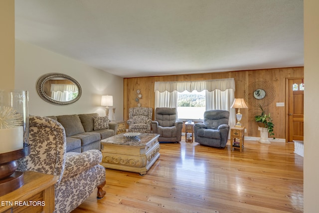 living room featuring wooden walls and light hardwood / wood-style floors