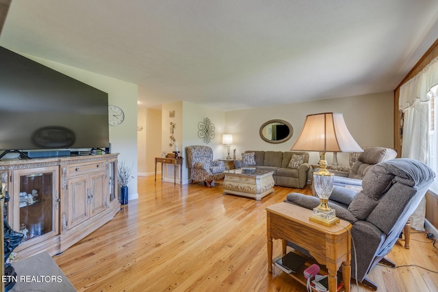 living area featuring light wood finished floors and baseboards