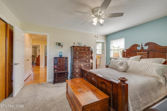 bedroom featuring light carpet, a closet, baseboards, and a ceiling fan