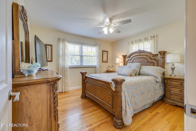 bedroom with ceiling fan, a textured ceiling, and light hardwood / wood-style floors