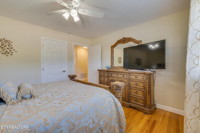 bedroom with baseboards, light wood-style flooring, visible vents, and a ceiling fan