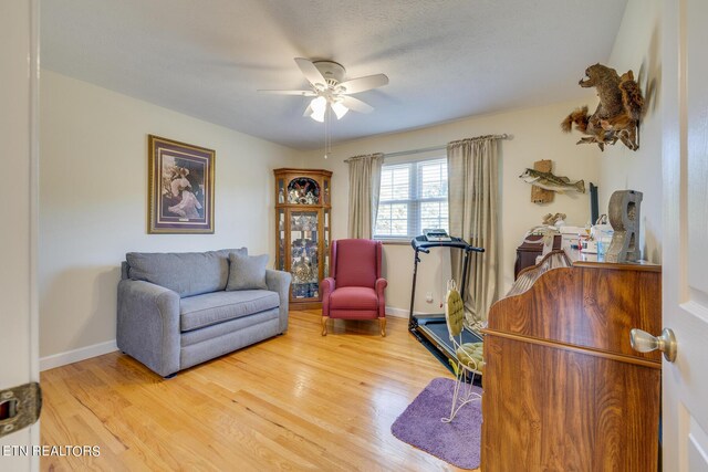 sitting room with ceiling fan, a textured ceiling, and hardwood / wood-style floors