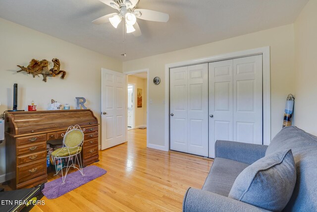 home office with light hardwood / wood-style floors and ceiling fan