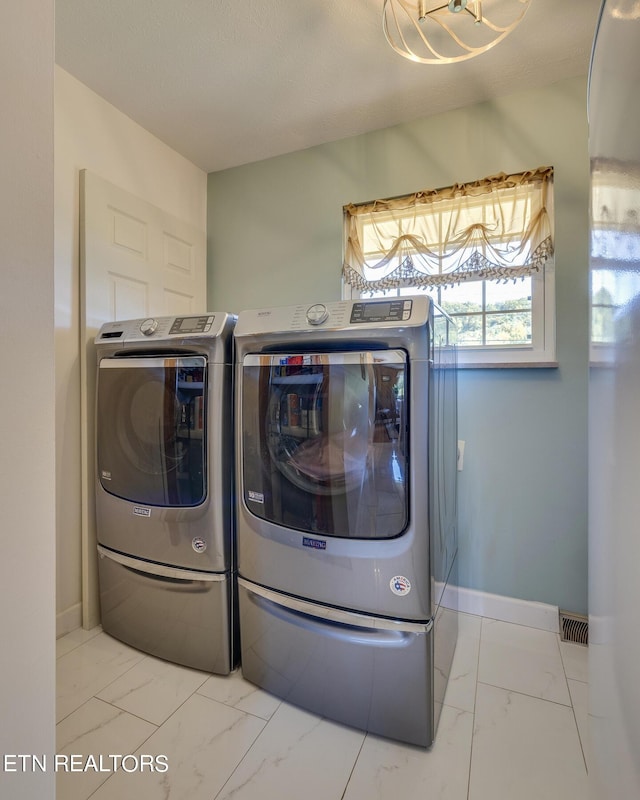 laundry area featuring marble finish floor, washing machine and dryer, laundry area, and baseboards