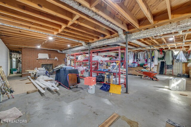 basement featuring a brick fireplace and brick wall