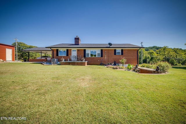 view of front of home featuring brick siding, a patio, a chimney, and a front lawn