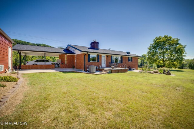 rear view of house featuring a yard, a patio, and central AC