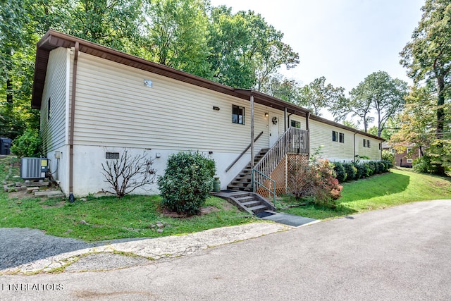 view of front of home with a front yard and cooling unit