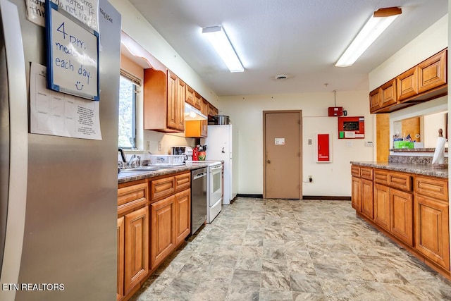 kitchen with baseboards, range, stainless steel dishwasher, a sink, and brown cabinetry