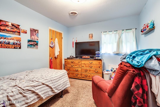 carpeted bedroom with a textured ceiling and visible vents