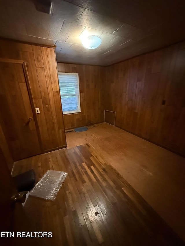 interior space with wood finished floors and wooden walls