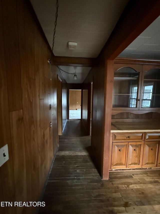 hallway with dark wood-style flooring and wood walls