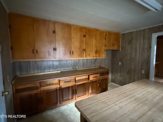 kitchen featuring wood walls and brown cabinets