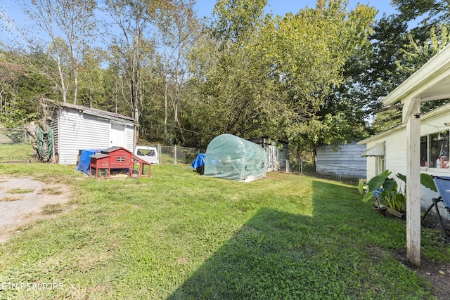 view of yard featuring an outbuilding, fence, and a storage unit