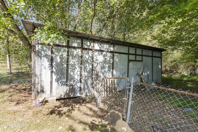 view of outbuilding featuring fence and an outbuilding