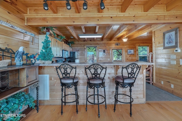 kitchen featuring wooden ceiling, light hardwood / wood-style flooring, and a breakfast bar area